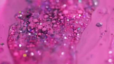 Parıldayan sıvı dökülmüş. Akrilik boya karışımı. Bulanık pembe renkli holografik pullar, sıvı mürekkep damlaları, emülsiyon parlatıcısı, soyut sanat arkaplanı, bokeh ışıkları..