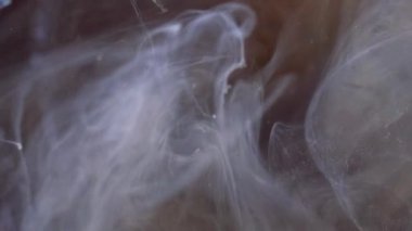 Parlak sis. Mürekkep su sıçratır. Odaklanmamış mavi altın rengi ışıldayan parçacıklar desen duman girdap hareketi soyut sanat arkaplanı.