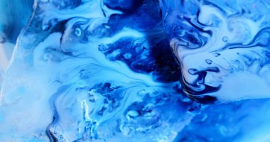 Mavi bilye. Boya akıntısı. Düz olmayan yüzeyde hafif kaotik sanat damlaları. Sıvı odaklı boya sızıntıları dekoratif girdaplarda dalgalanıyor..