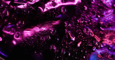 Titreyen çiy taneleri. Mor damlalar. Mistik çözünmüş parlak bölge, akan su buharlaşması ile kaplı. Pürüzsüz menekşe nem arkaplan dokusu.