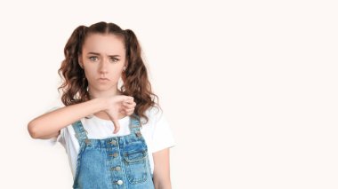 Reddetme jesti. Hayır işareti. Kötü fikir anlaşmazlığı hayal kırıklığı. Şüpheci genç kız beyaz fotokopi arkaplanında izole edilmiş başparmaklarını gösteriyor.