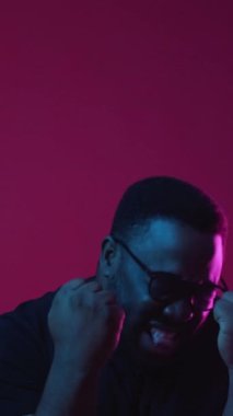 Dikey video. Zafer sevinci. Kutlamayı kazan. Tuhaf bir ruh hali. Mutlu, heyecanlı, komik adam piyango başarısıyla tatmin olmuş, çığlık çığlığa evet diye bağırıyor, şarap rengi arka planda izole bir şekilde dans ediyor..