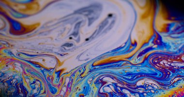 Soyut arkaplan. Damlacıklar akar. Odaklanamayan mor renkli, yeşil renkli gökkuşağı eğrisi koyu siyah, bulanık ışık sanatında akrilik kaygan.