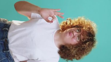 Dikey video. Tamam jest. Onay evet. Tatmin olmuş, gözlüklü tombul kız mavi üzerinde mükemmel el işareti gösteriyor..