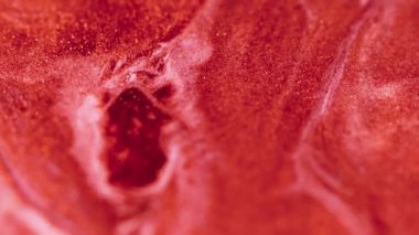 Parlak sıvı karışımı. Boya akışı. Odaklanmamış kırmızı turuncu altın rengi parıldayan mürekkep sızıntısı, dalga hareketi soyut sanat arkaplanı.