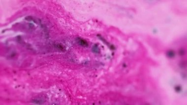 Parlak boya. Mürekkep akışı. Parlak parıltı. Odaklanmamış pembe beyaz renk parıltılı sıvı sızıntısı büyüleyici kozmetik sıvısı ışkan parçacıklar hareketli soyut sanat arka planı.