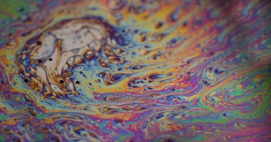 Soyut dağılım. Hafif sıvı köpük. Odaklanmamış mor, yeşil yağ rengi eğrisi koyu siyah bulanık sanat arka planında akrilik kaygan.