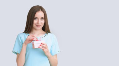 Party fun. Festive joy. Smiling satisfied beautiful happy woman in blue with present in box isolated on light copy space background. clipart