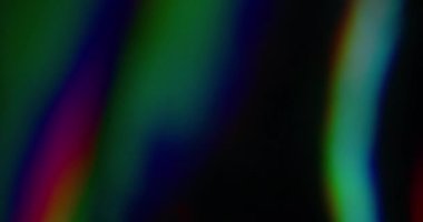 Gökkuşağı renkleri. Bulanık ışık yayılıyor. Odaksız sızıntı, yeşil ışınlar titreşimler, ışık çizgileri, koyu siyah soyut sanat arka planında parlamalar..