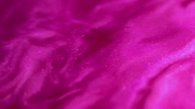 Pembe dalga. Parıltılı boya sıçraması. Bulanık morumsu renk parıldayan parçacıklar sıvı mürekkep harmanlama hareketi soyut sanat arkaplanı.