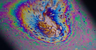 Psikedelik boya. Sabun köpükleri. Odaklanmamış mor yeşil sıvı boya gökkuşağı eğrisi akrilik kaygan koyu siyah bulanık ışık soyut sanat arka planı.