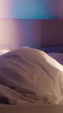 Dikey video. Gece nöbeti. Gizli online sohbet. İtaatsiz genç adam, ebeveyn kontrolünden gelen telefonla battaniyenin altında saklanıyor..