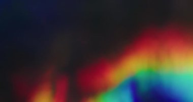 Gökkuşağı merceği parlıyor. Bulanık ışın titreşimi. Odaklanamayan sızıntı, çok renkli, yeşil, parlak ışınlar, koyu siyah, soyut, aydınlık sanat arkaplanı..