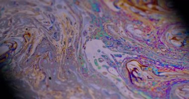 Psikedelik akış. Sıvı çok renkli. Odaklanmamış mor turuncu, mavi, turuncu, sıvı yağ eğrisi koyu siyah, bulanık ışık, soyut sanat arka planında akrilik kaygan..