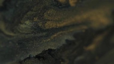 Parıltılı jel boya. Mürekkep arkaplanı. Parlak yeşil siyah sıvı akışkan akrilik altın parıltılı karışık hareket hipnotik mistik soyut doku.