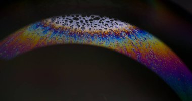 Boya karışımı. Köpüklü sıvı. Odaklanmamış mor gökkuşağı eğrisi akrilik kaygan koyu siyah soyut bulanık bokeh hafif sanat arka planı.