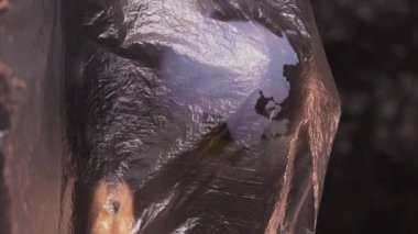 Dikey video. Doğa koruma. Sürdürülebilir gezegen. Plastik polietilen film, koyu renkli taze organik meyve kompozisyonu içeren küreyi ortaya çıkardı..