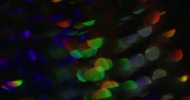 Soyut çok renkli gökkuşağı. Bulanık psikedelik ışık. Odaklanmamış toz sızıntısı, yeşil sarı ışınlar, yanıp sönen mercekler, koyu siyah sanat arkaplanda parıldıyor..