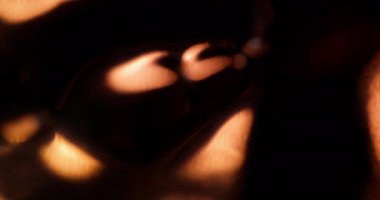 Soyut ışın. Odaklanamayan parıltı. Parıldayan ışıldayan görkemli mercek altın sarısı parlayan parıltılar sanatın karanlık arka planında parıldıyor..