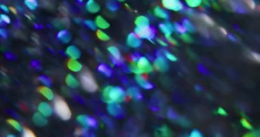 Bulanık soyut ışıltılar. Noel şenliği. Odaklanmamış toz sızıntısı. Çok renkli yeşil ışınlar. Gökkuşağı titreşimleri..