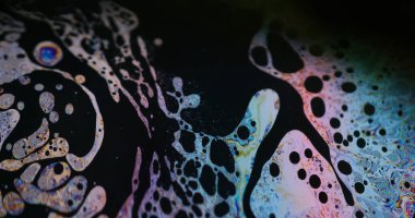 Soyut sanat. Sıvı sabun köpüğü. Odaklanmamış mor yeşil sıvı yağ eğrisi koyu siyah bulanık ışık arka planında akrilik kaygan.