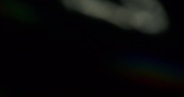 Büyüleyici soyut doku. Bulanık gökkuşağı gölgeleri. Odaklanamayan sızıntı, çok renkli yeşil ışınlar, siyah sanat ışığı arka planında yanıp sönen ışın mercekleri..