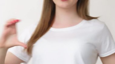 Destekleyici kız. Aşk mesajı. Beyaz tişörtlü heyecanlı bir gencin portresi. Hava öpücüğü. Açık alan arka planında izole edilmiş kalp işaretini gösteriyor..