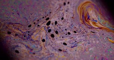 Yanardöner sıvı. Sıvı damlalar akar. Odaklanamayan mor renkli, yeşil yağlı boya eğrisi koyu siyah, aydınlık, soyut sanat arka planında akrilik kaygan..