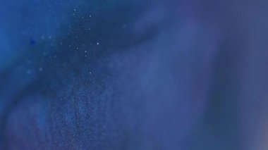 Işıldayan akış. Parıltı hareketi. Odaklanmamış mavi mor renkli parlak boya parçacıkları dokusu soyut büyülü sanat arkaplanı karışımı.