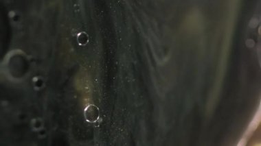 Lüks mürekkep. Parıldayan boya. Odaklanamayan siyah altın rengi yüzen şeffaf yağ kabarcıkları ışıldayan parçacıklar parıltı emülsiyon hareketi soyut sanat arka planı.