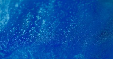 Bulanık parlak kıvılcımlar. Parıltılı akış. Yanıp sönen mavi renk sıvısı parlayan sıvı boya mürekkebi parlak toz soyut bokeh ışık arka planında hareket ediyor.