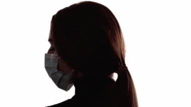 Hava kirliliği. Yüz silueti. Çevresel bir sorun. Beyaz boş alanda izole edilmiş koruyucu maskeli kadın başının koyu arka plan çizgisi..