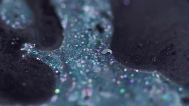 Parlayan yağ. Mürekkep sıvısı. Odaklanmamış mavi renkli holografik parçacıklar boya damlaları jel damlaları hareket damlaları soyut sanat arkaplanı ve bokeh ışıkları.