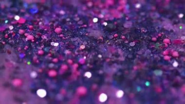 Parıltı dalgası. Parıltılı boya döküldü. Mor, pembe, parlak, pullu, pullu parçacıklar. Sıvı, emülsiyon, mürekkep damlaları. Bokeh ışıklarıyla soyut sanat arka planı..