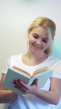 Dikey video. İyi okumalar. Boş zamanlarımda kitap okurum. Rahat akıllı kadın ilginç masal edebiyatından zevk alıyor. Pastel renkli fotokopi alanı arka planı üzerine..