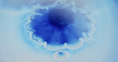 Yağ akışı. Bulanık parıltı dokusu. Mavi beyaz renk parıldayan parçacıklar boya damlası mürekkep dalgası soyut sanat arka planına düşüyor.