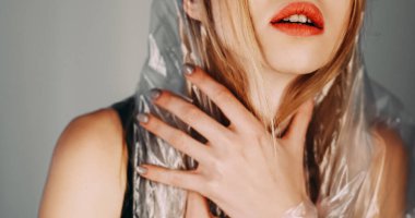 Anksiyete sorunu. Panik atak. Gri arka planda izole edilmiş polietilen film başlığı giyen rahatsız paranoyak ve güvensiz bir kadının sanat portresi..