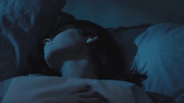Kabus korkusu. Kötü bir rüya. Uyku bozukluğu. Karanlik yatak odasinda karabasandan uyanan huzursuz bir kadin..