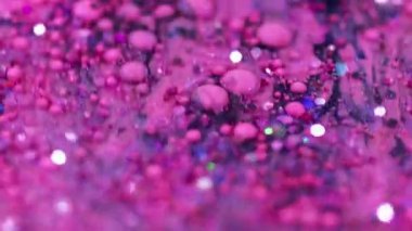 Kabarcık akışı. Akrilik boya karışımı. Bulanık pembe renkli holografik pullar, sıvı mürekkep damlaları, emülsiyon parlatıcısı, soyut sanat arkaplanı, bokeh ışıkları..