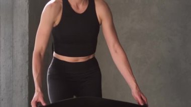 Fiziksel antrenman. Fitness egzersizi. Spor elbiseli atletik bir kadın spor salonundaki spor salonunda egzersiz yapmadan önce yerde yoga minderi açıyor..