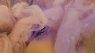 Pırıltılı sis. Renkli su. Pembe sarı mürekkep gazı seyrek pastel bulut kıvrımlı sihirli menekşe yuvarlak şekilli zebra efekti soyut arka plan.