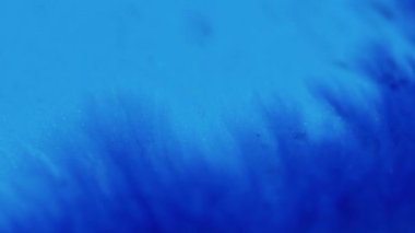 Parlayan sıvı. Yapışkan damlalar. Parlak mürekkep dokusu. Odaklanmamış parlak mavi renk parıldayan boya karışımı dalga hareketinin soyut sanat arkaplanı.
