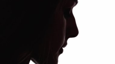 Üzgün surat. Kadın silueti. Hayal kırıklığı yalnızlık. Koyu renk karşıtlık profili, üzgün, depresif bir kadının beyaz boş alana izole edilmiş bakışları..