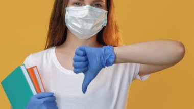 Karantina reddediyor. Salgın protestosu. COVID-19, uzaktan eğitim, koruyucu yüz maskesi eldivenli şüpheci kadın fotokopi uzayı izole edilmiş baş parmak hareketi ile hayır gösteriyor..