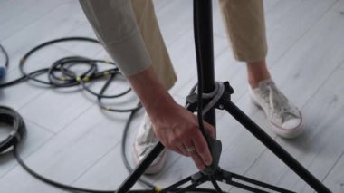 Operatör ışığı. Spot ışığını açıyorum. Adam tripodla profesyonel büyük lambayı çalıştırıyor. Stüdyo teknisyeni çekim cihazını ayarladı.