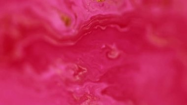 Boya sızıntısı. Parıldayan sıvı dökülmüş. Odaklanmamış morumsu pembe altın rengi ışıltılı dokusu sıvı akış hareketi soyut sanat arkaplanı.