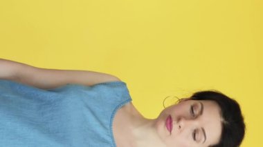 Dikey video. Neşelen biraz. Beklenmedik bir hediye. Kese kağıdında hazır bulunan üzgün kadın mutlu, mutlu, minnettar yüz ifadesi sarı boş alanda izole edilmiş..
