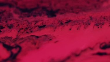 Parlak boya sıvısı. Parıltı damlaları. Yüzen yapı. Odaklanmamış siyah kırmızı renk parıldayan desen mürekkebi akış hareketi soyut sanat arkaplanı.