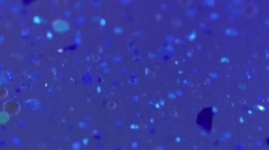 Jel parçacıkları Işıldayan sıvı dalgası. Bulanık mavi renk parlak pullu şeffaf sıvı parlatıcı desen boya su sızıntısı soyut sanat arkaplanı Bokeh ışıkları.