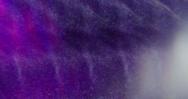 Bulanık toz parçacıkları. Işıltılı akış. Beyaz ışıl ışıl şeffaf toz, parlak su sıçratır soyut bokeh açık mor çok renkli arka planda hareket eder.